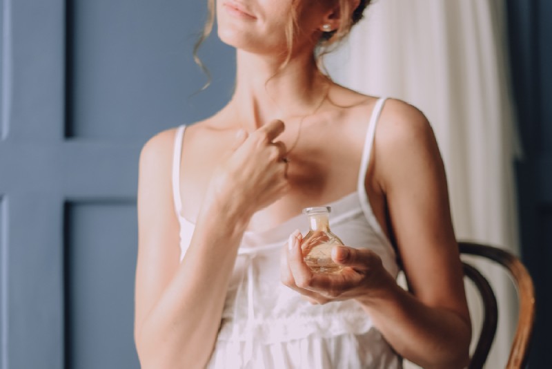 Une femme mettant un parfum
