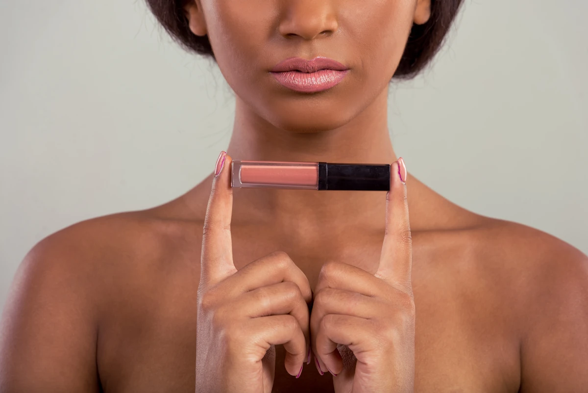Une femme qui tient un gloss dans ses mains