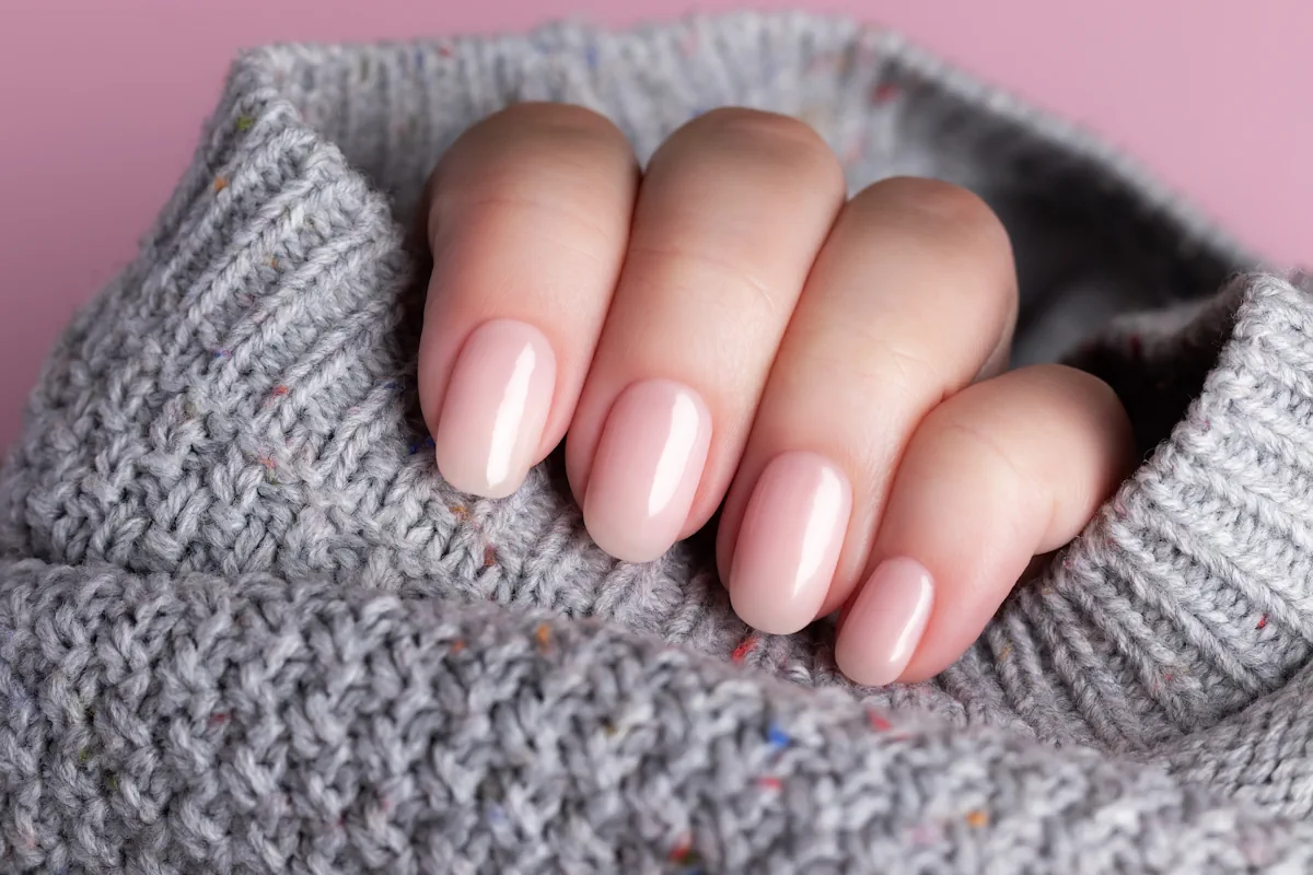 Une personne qui montre la forme de ses ongles