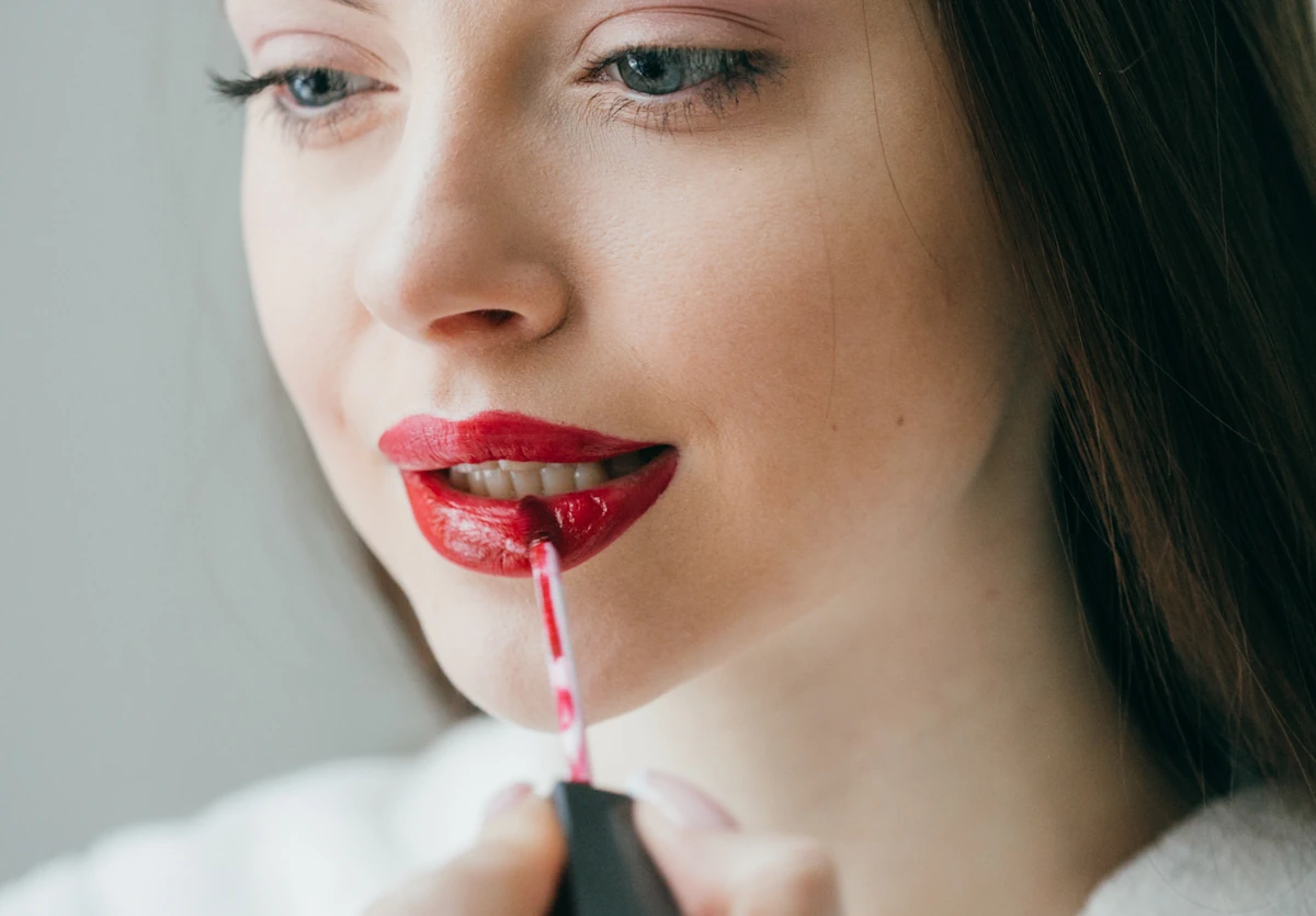 Une femme qui applique du gloss teinté sur la bouche